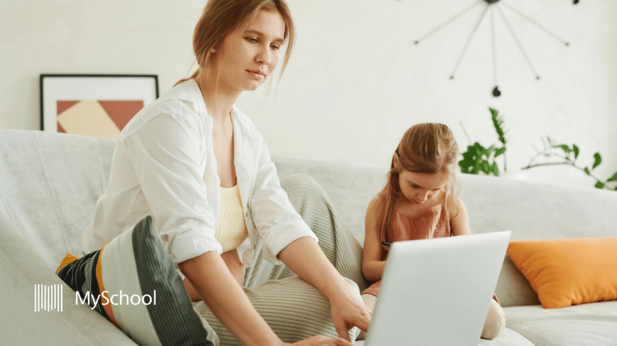 Parent and child using a school communication platform and online learning tools at home