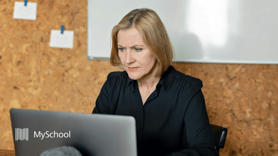 School administrator using school administration software to review reports and manage daily operations