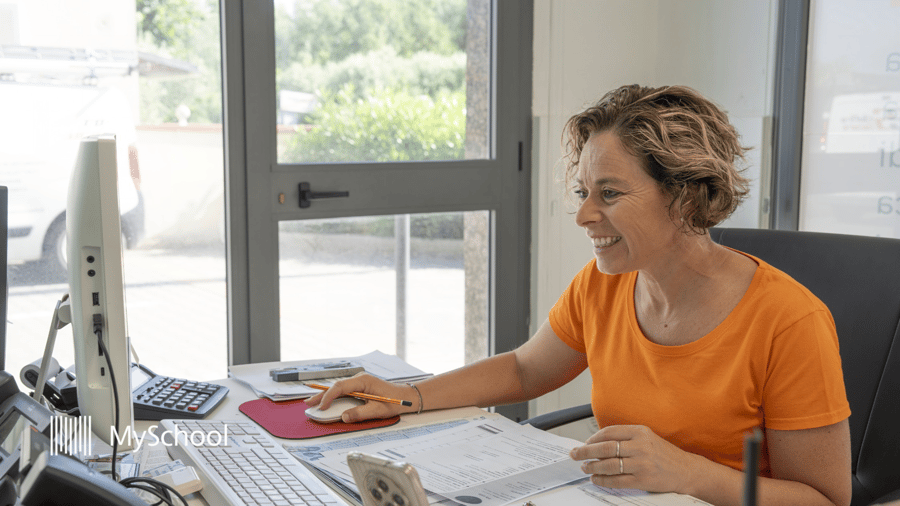 School administrator using school administration software to review reports and manage daily operations