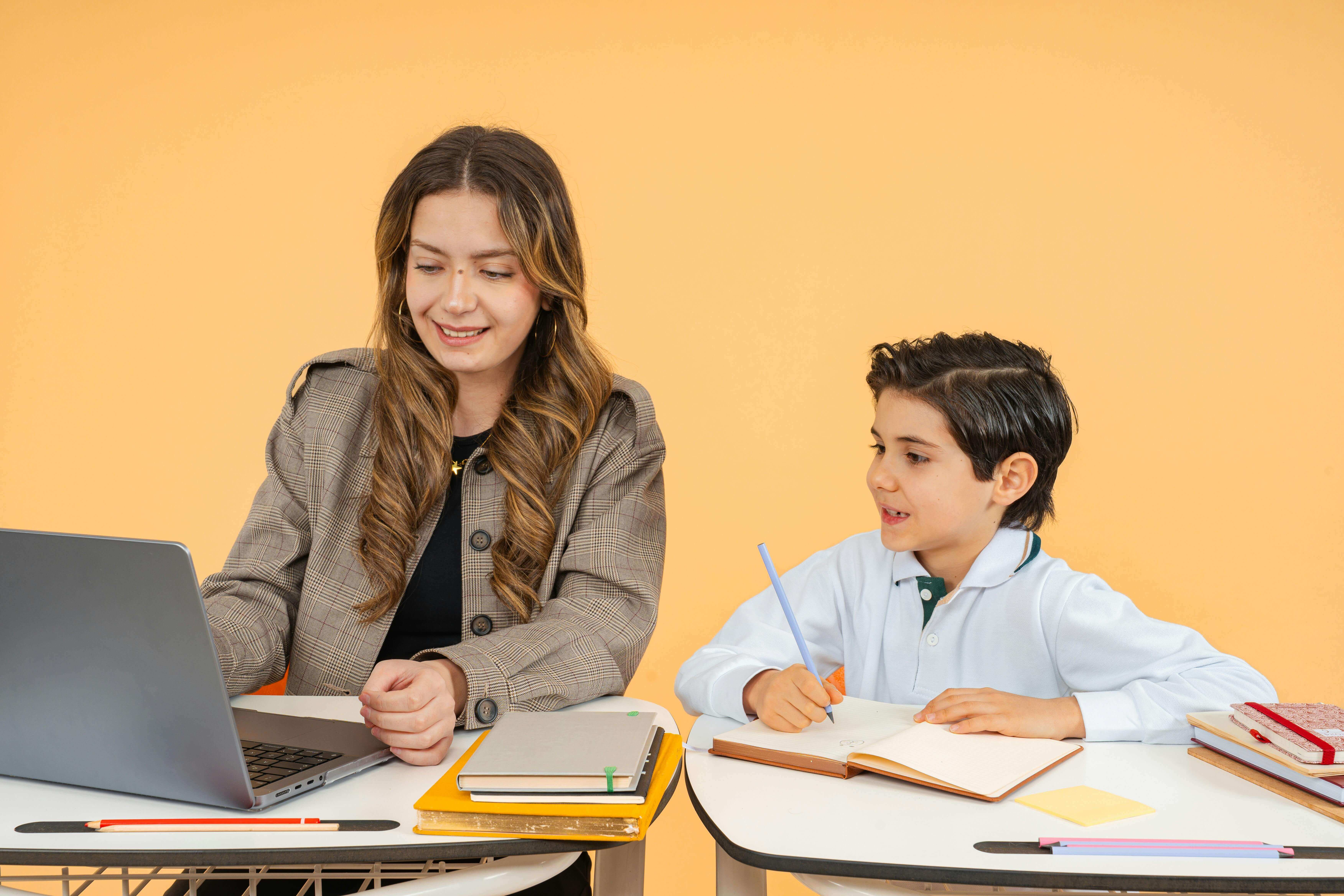 Teacher and student accessing information together on a laptop in the classroom