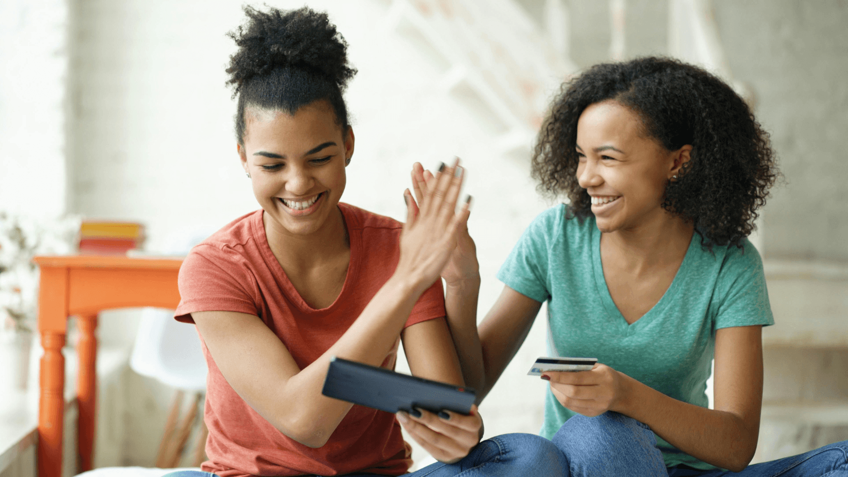 Two alumni successfully completing an online donation payment together using MySchool platform on tablet