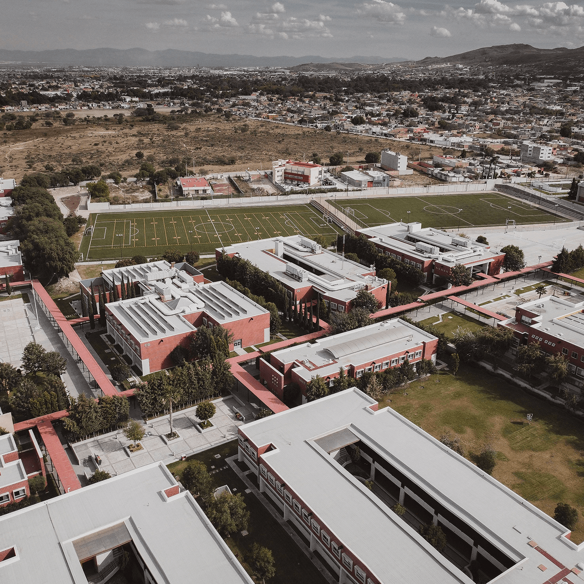 Aerial view of a school campus showing multiple interconnected academic and athletic buildings